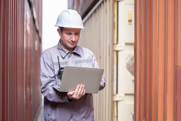 Logistics manager analyzing data in shipping container yard warehouse environment professional...