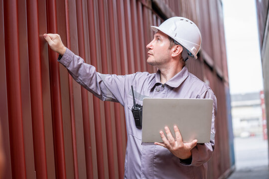 Inspector assessing shipping container integrity warehouse professional portrait industrial environment side view safety protocols - Powered by Adobe