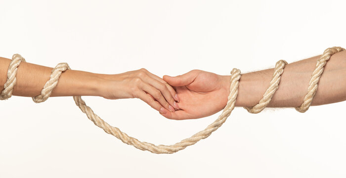 the hands of a man and a woman tied with a rope touch each other