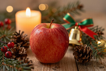 Cozy Holiday Still Life with Fresh Red Apple, Warm Candlelight, and Festive Winter Decorations on a Rustic Wooden Table