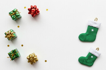 Minimalist Christmas flat lay with festive gift boxes and traditional green stockings on a clean white background, perfect for holiday season greetings and celebrations