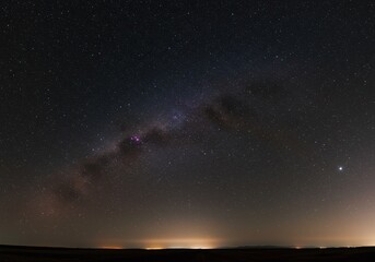 Fototapeta premium A breathtaking panoramic view of the deep dark night sky filled with countless brilliant stars and distant galaxies above the horizon ,night ,darkness ,beautiful