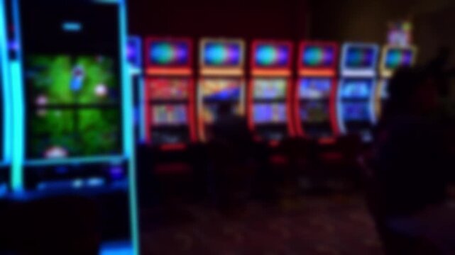 Colorful neon slot machines with women playing in a modern casino, showcasing bright screens and an energetic gambling atmosphere.