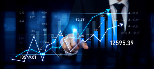 A business professional interacts with a digital interface displaying financial graphs and data in a dark setting, showcasing trends and growth in stock market analytics. Scalp