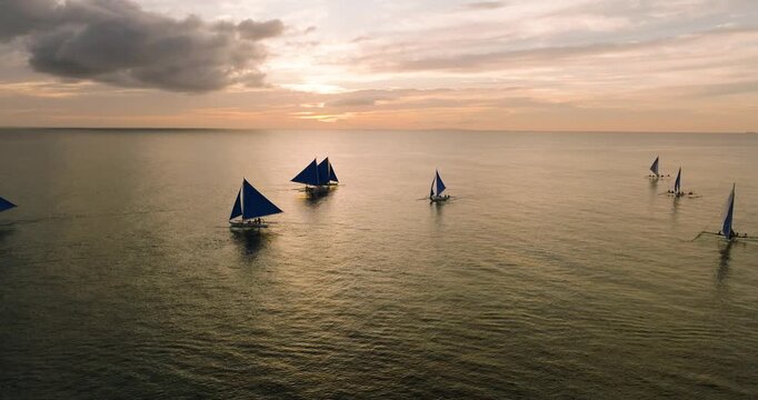 Sailboats roaming over the sea with cloudy sunset background. Boracay, Philippines.
