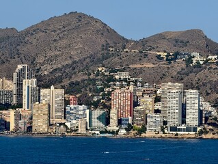 scenic seaside harbor with mountains, picturesque harbor nestled between mountains and apartments