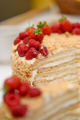 A Tasty Fluffy Layered Pastry With Rich Cream And Fresh Red Raspberries Sitting On A Plate Near The Whole Cake