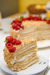 A homemade delicious layered honey cake, decorated with berries on top, close-up. It's so tasty! Let's try it!