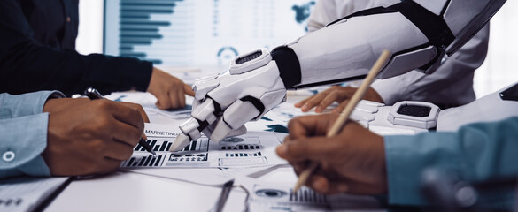 A robotic arm collaborates with a diverse team during a business meeting, aiding in data analysis and strategy development for future innovations.Noogenesis