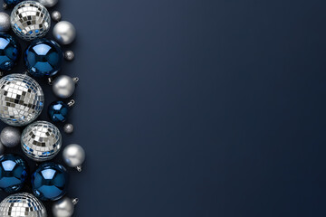 Arrangement of red Christmas ornaments and blue and silver disco balls creates a festive, modern holiday scene suitable for Christmas and New Year greetings and seasonal decor.