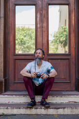 Man with vintage camera seen sitting on stairway