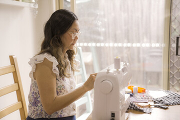 Asian middle aged woman using sewing machine, reuse zero waste project, sustainable living, home stuido small business