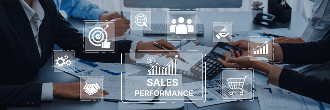 Professionals engage in a collaborative meeting, analyzing sales performance metrics with digital tools and documents, aimed at enhancing business strategy and growth. Trope - Powered by Adobe