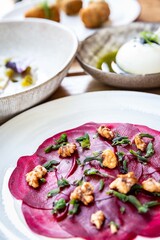Beetroot carpaccio salad with walnuts and herbs at a restaurant