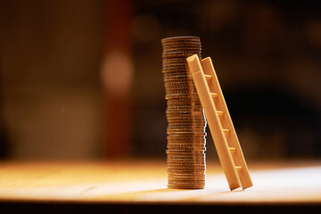 stack of coins with leaning step ladder