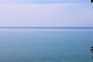 Obraz premium Minimalist View of the Calm Blue Ocean and Horizon Under a Hazy Sky