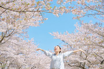 桜の前で深呼吸する女性