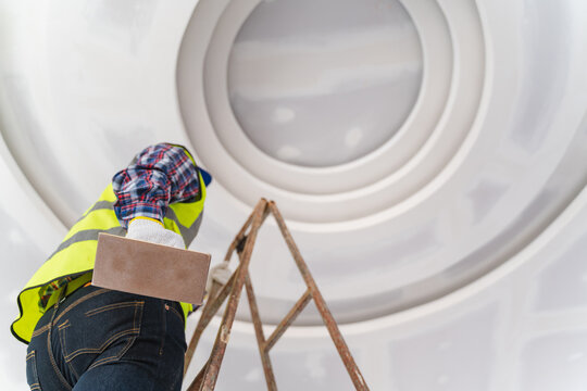Construction Worker Applying Finishing Touches to Ceiling During Renovation Project with Focus on Detail and Precision in Modern Interior Space