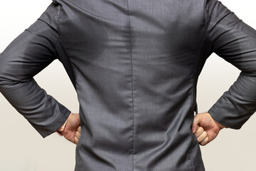 Confident businessman in sweaty suit standing with hands on hips, isolated on a white background