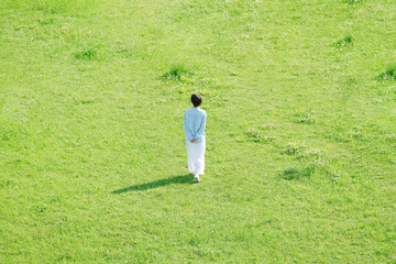 野原を散歩する女性　後ろ姿　俯瞰撮影