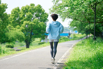 屋外でランニングする40代女性　後ろ姿