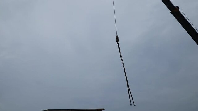 Construction install roof trusses under a crane without safety harnesses. Footage taken in Java, Indonesia, on October 14, 2025.