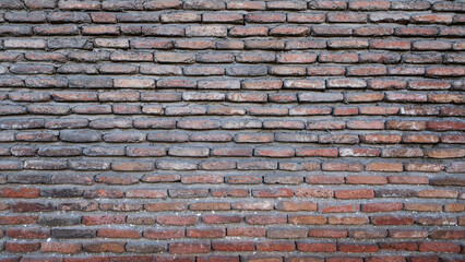 A detailed view of a neatly aligned brick wall, showing layered texture and symmetry. The warm earthy tones and solid construction reflect traditional brickwork design.