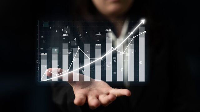 A businesswoman displays a digital financial growth chart, illustrating rising trends and market indicators, symbolizing success and data-driven analysis in business. Impute