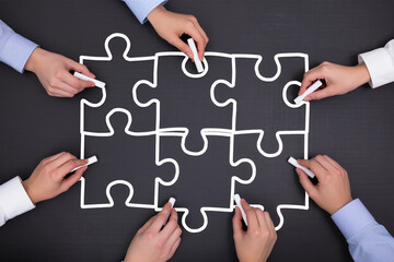 Finding solution of business relationship, Successful business team concept and Businessmen drawing puzzle pieces on chalkboard