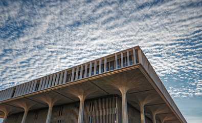 White and Blue Checkered Sky Above a Square Building Roofline.