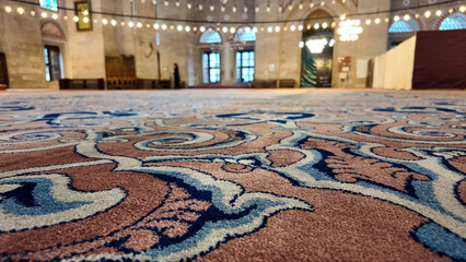 Intricate carpet design in a large mosque interior setting