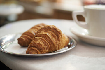Fresh croissants and coffee at a cozy cafe table