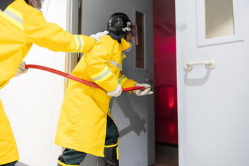 Team of firefighters open the door to extinguish fire in a burning room