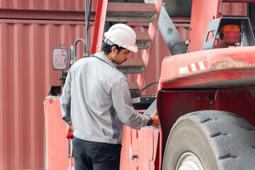 Industrial worker inspecting heavy machinery at container yard, Technician checking forklift...