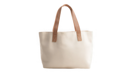 A cream colored tote bag with brown handles isolated against a black background in a studio shot