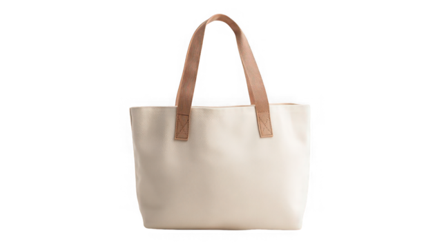A cream colored tote bag with brown handles isolated against a black background in a studio shot