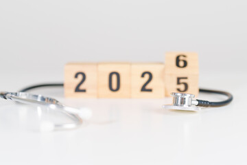 2025 end year to Happy New Year 2026 with Stethoscope of doctor and heart shape on table. health care, Insurance, Wellness and medical concepts