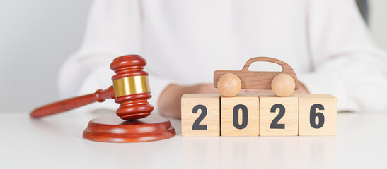 2025 end year to Happy New Year 2026 with small toy car models and Judges gavel on desk in...