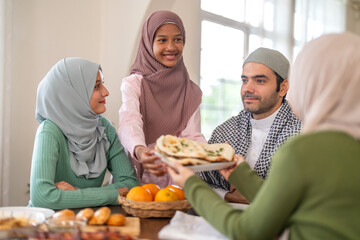 Muslim big family sharing traditional meal together around dining table wearing hijabs and kufi in cultural love, ramadan iftar celebration, eid al-fitr festive, halal meal gathering food culture
