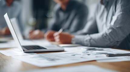 business team brainstorming in creative workspace, laptops and charts on table, modern technology, professional attire, dynamic composition
