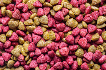 Combined vitaminized dry pet food. Yellow and pink dry food