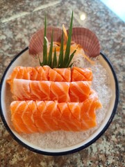 Thinly sliced ​​salmon fillet placed flat on a bowl of ice.