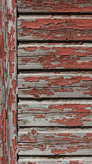 Close up of old wooden wall with peeling red paint, worn texture. Weathered surface for rustic background. Vintage, abstract concept.