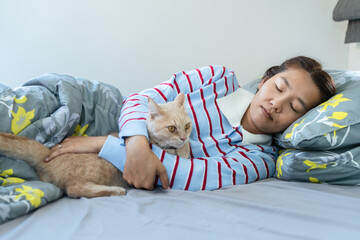 Peaceful woman napping and hugging orange tabby cat in bedroom showing love and strong bond.
