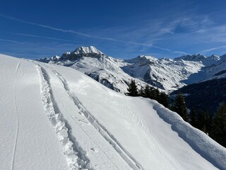 Wonderful winter hiking trails and traces in the fresh alpine snow cover of the Swiss Alps and over...