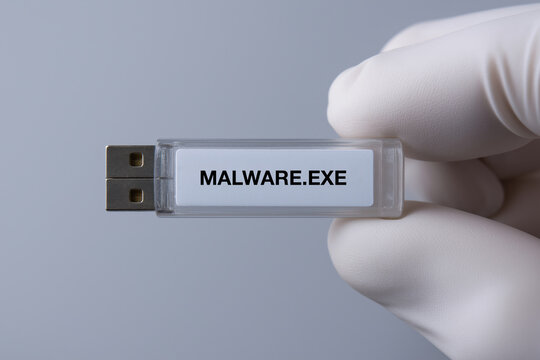 Hand holding usb drive with malware.Exe message