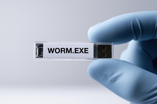Gloved hand holding usb drive with worm virus