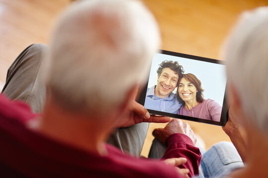 Tablet screen, video call and senior couple in home, contact family and happy for talk in lounge. Elderly people, tech and ux with application, virtual chat or excited for communication in retirement - Powered by Adobe