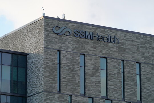Modern SSM Health building exterior with logo signage on a textured gray facade under a bright sky, suitable for healthcare, corporate, or financial.