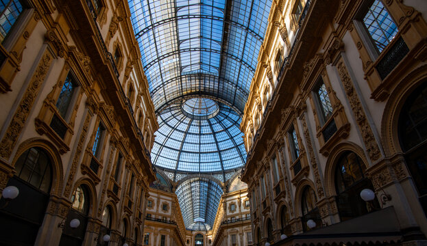 Sunlight through glass dome Historic Milan. Classic ornate ceiling Tourist landmark Milan view. Glass dome over gallery interior in Milan. Classic European landmark in Milan.
